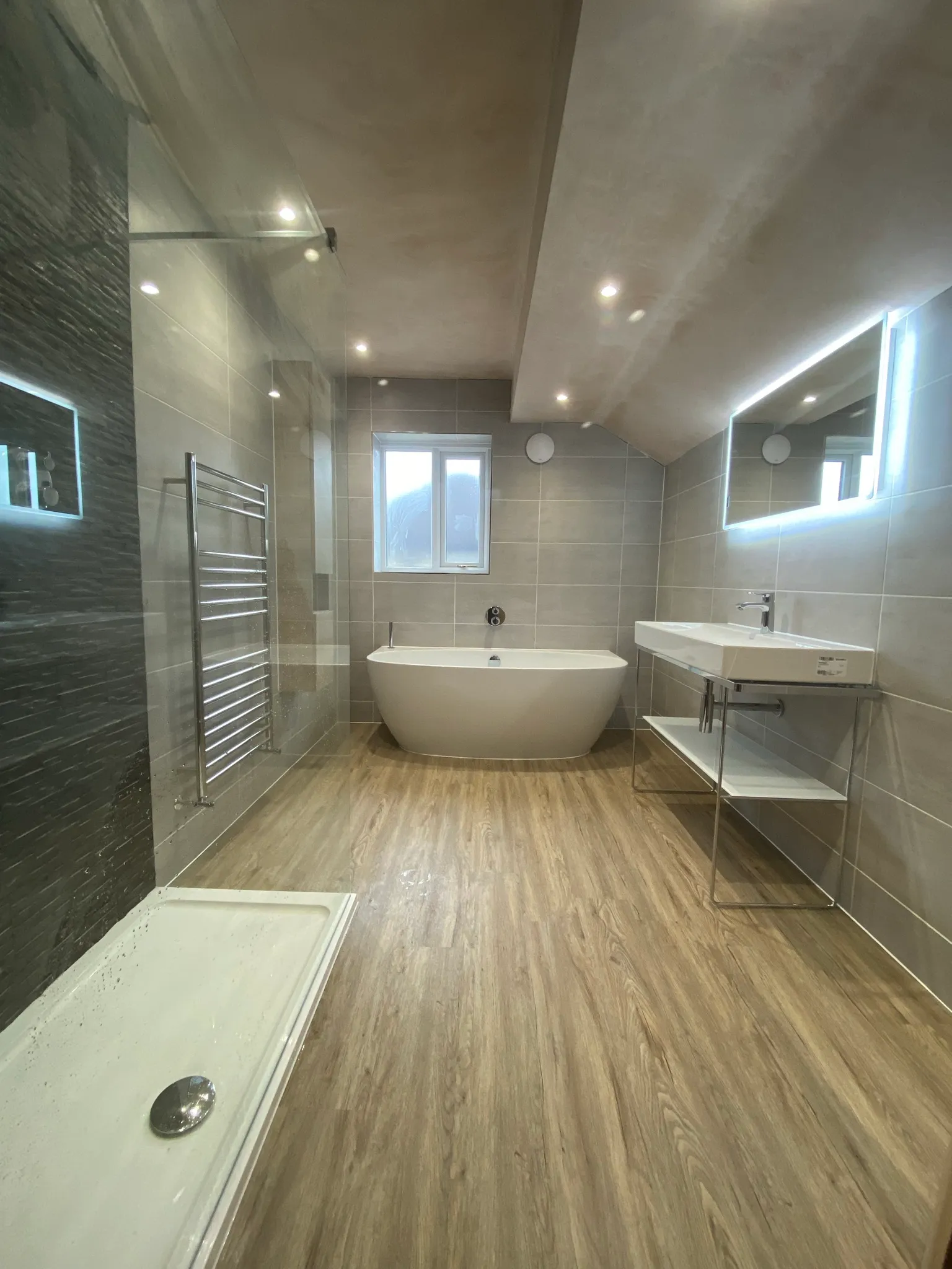 Finished bathroom renovation with a freestanding bath, split-face feature wall and walk-in shower
